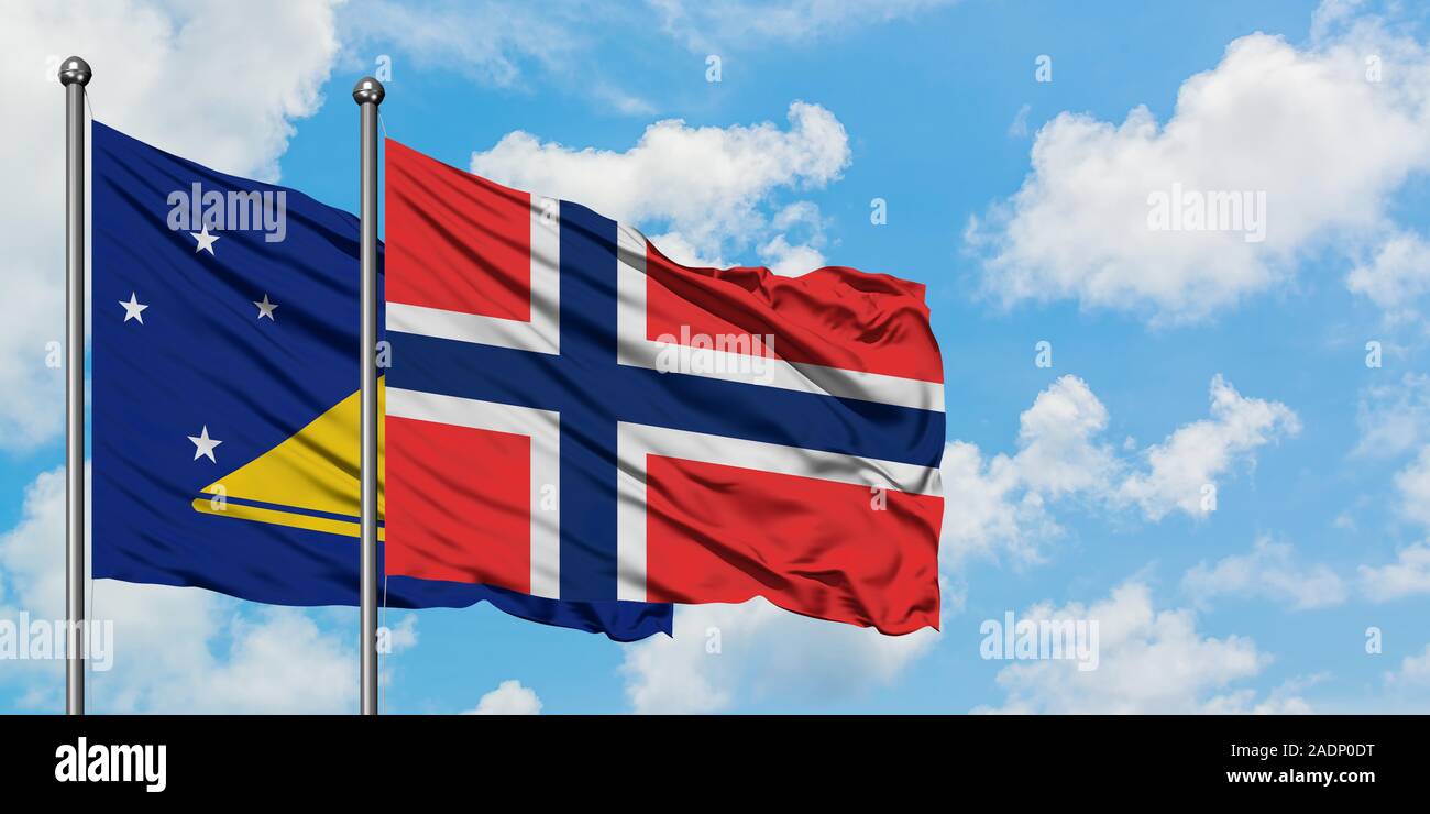 Les Tokélaou et de brandir le drapeau des Îles Bouvet dans le vent contre ciel bleu nuageux blanc ensemble. Concept de diplomatie, de relations internationales. Banque D'Images
