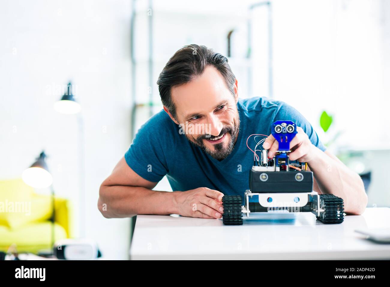 Heureux homme barbu en utilisant son robot à la maison Banque D'Images