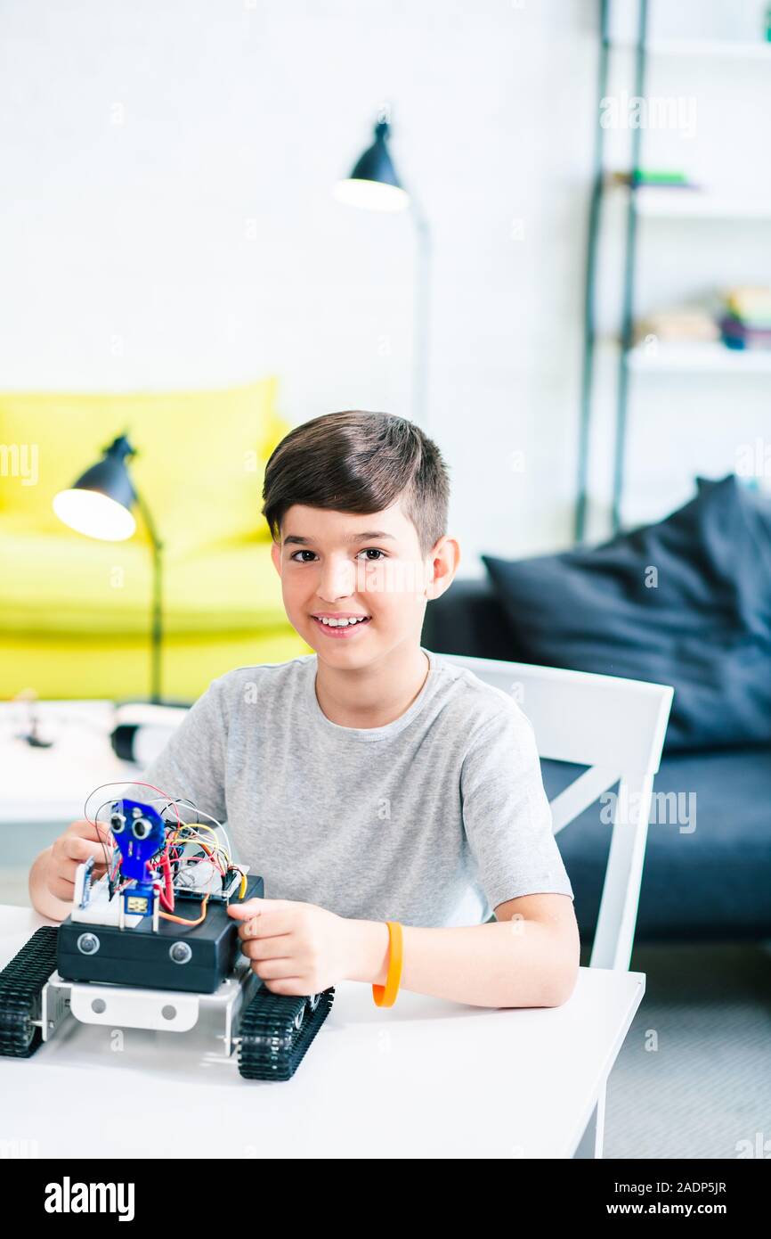 Jusqu'à la taille d'une joyeuse smiling boy à l'aide de technologies robotiques Banque D'Images