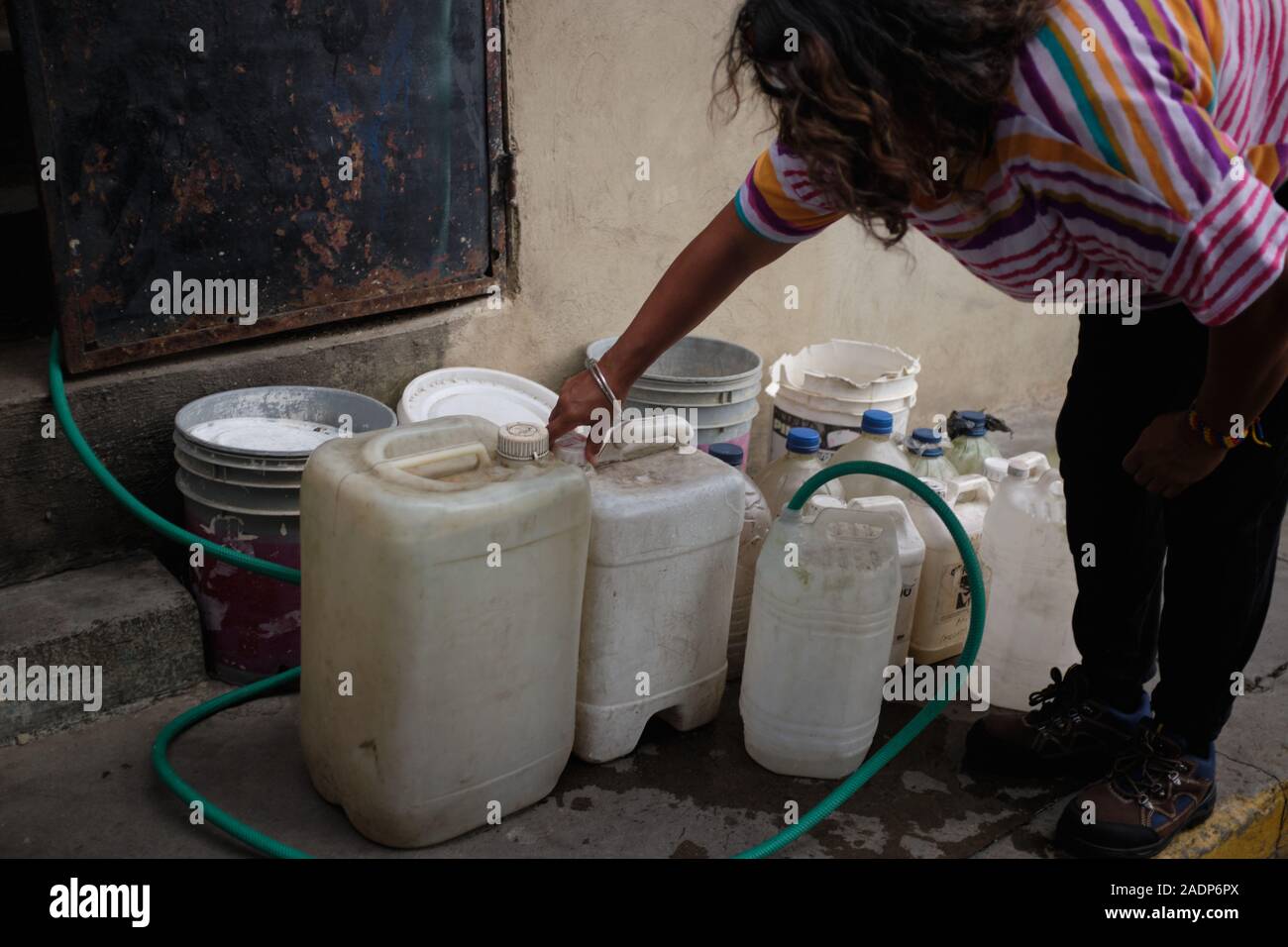 Caracas, Venezuela, Miranda. 29 Nov, 2019. L'eau de remplissage aura contaners avec l'eau de la maison de la soeur de l'Aura.Aura Graciela Sarmiento, l'âge de 56 ans, et son mari Jose Alberto Abreu, 62 ans, n'ont pas eu l'eau courante dans leur maison en 4 ans. Aura travaille dans un magasin de vente de mobilier de bureau, et Jose est un mécanicien. Ils vivent dans le quartier d'Altos de Lidice à Caracas au Venezuela. Altos de Lidice est un quartier historique Chavista. Cependant, l'Aura est pro-opposition, et n'a jamais appuyé le régime de Chavez, même si elle a vécu dans ce pro-Chavez/Maduro barrio toute sa vie Banque D'Images