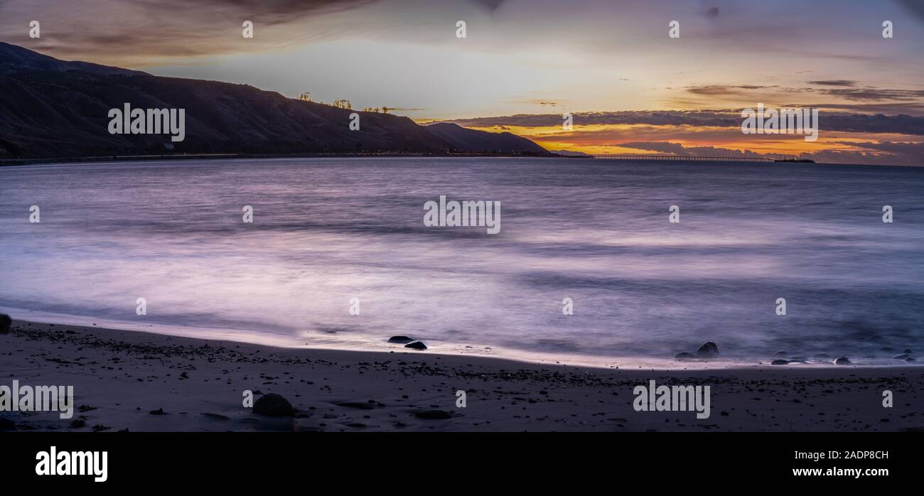 Vue panoramique sur aube lumière briser derrière des collines côtières et jetée en bois et l'île de Californie. Banque D'Images