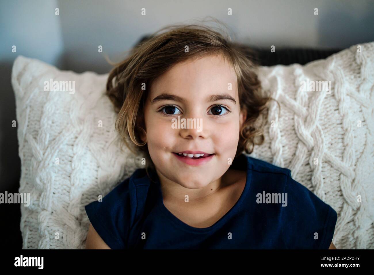 Superbe jeune fille de 4 ans avec d'immenses yeux bruns looking up and smiling Banque D'Images