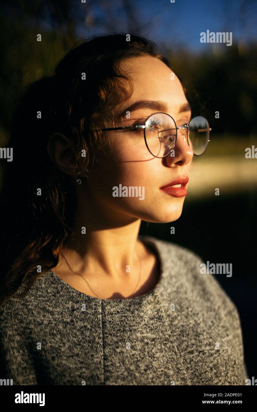 Portrait de profil d'une jeune femme dans un manteau gris Banque D'Images