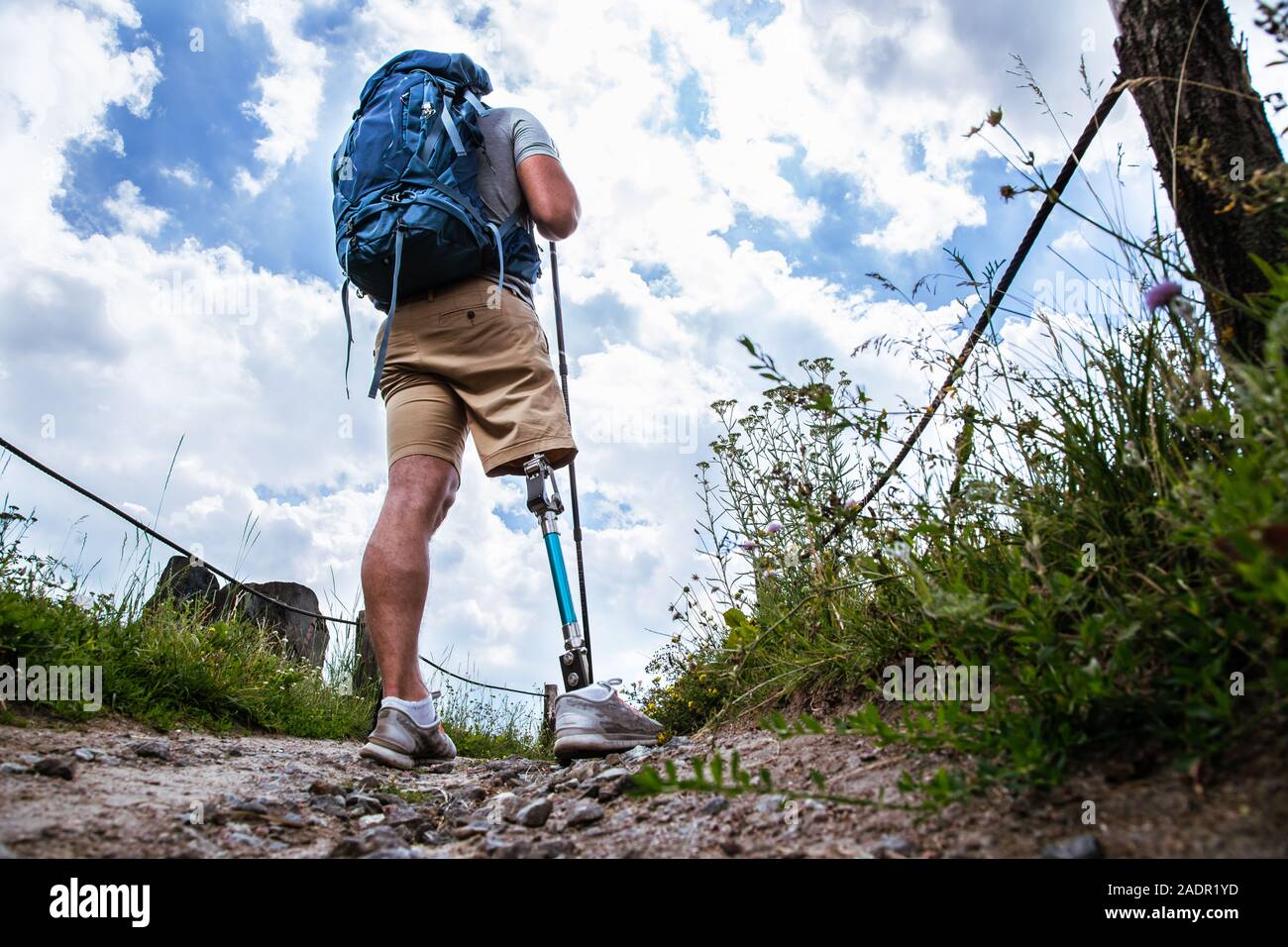 Vue arrière d'un jeune homme sportif avec une prothèse debout sur le chemin Banque D'Images