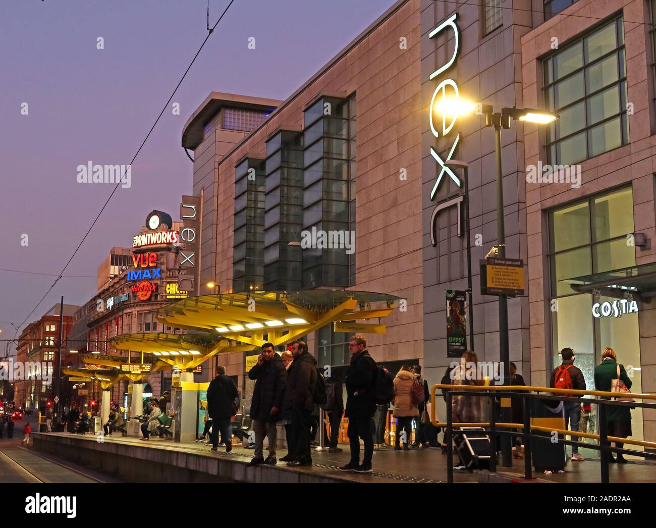 Arrêt de tramway Manchester Exchange Square Metrolink, à côté du centre commercial Arndale, Next, centre-ville, Manchester, Angleterre, Royaume-Uni, au crépuscule Banque D'Images