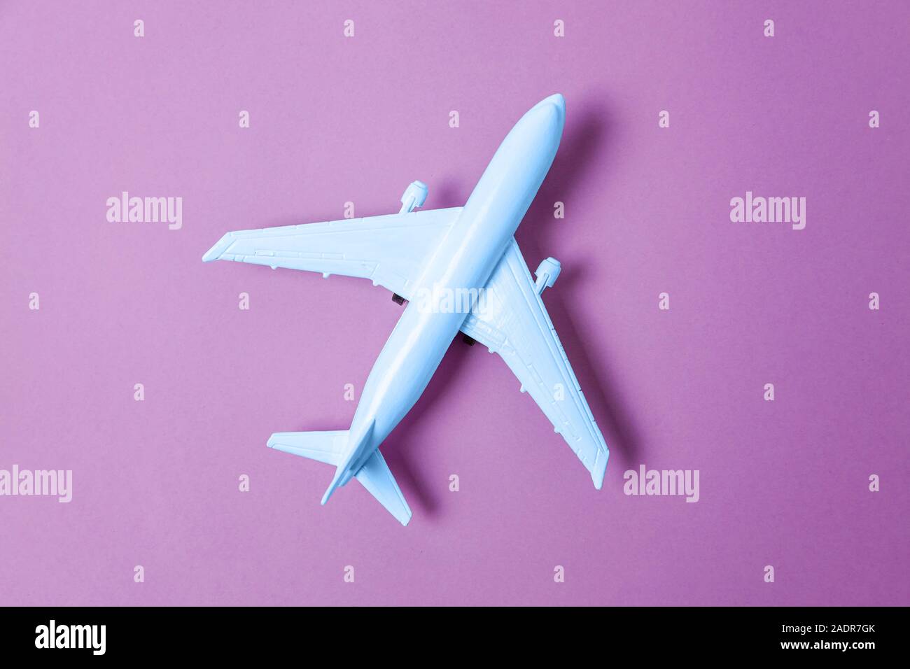 Télévision simplement jeter l'avion jouet design colorés en couleur tendance de l'année 2020 classique bleu violet sur fond violet. Couleur 19-4052 Macro lumineuse. Par Voyage Banque D'Images