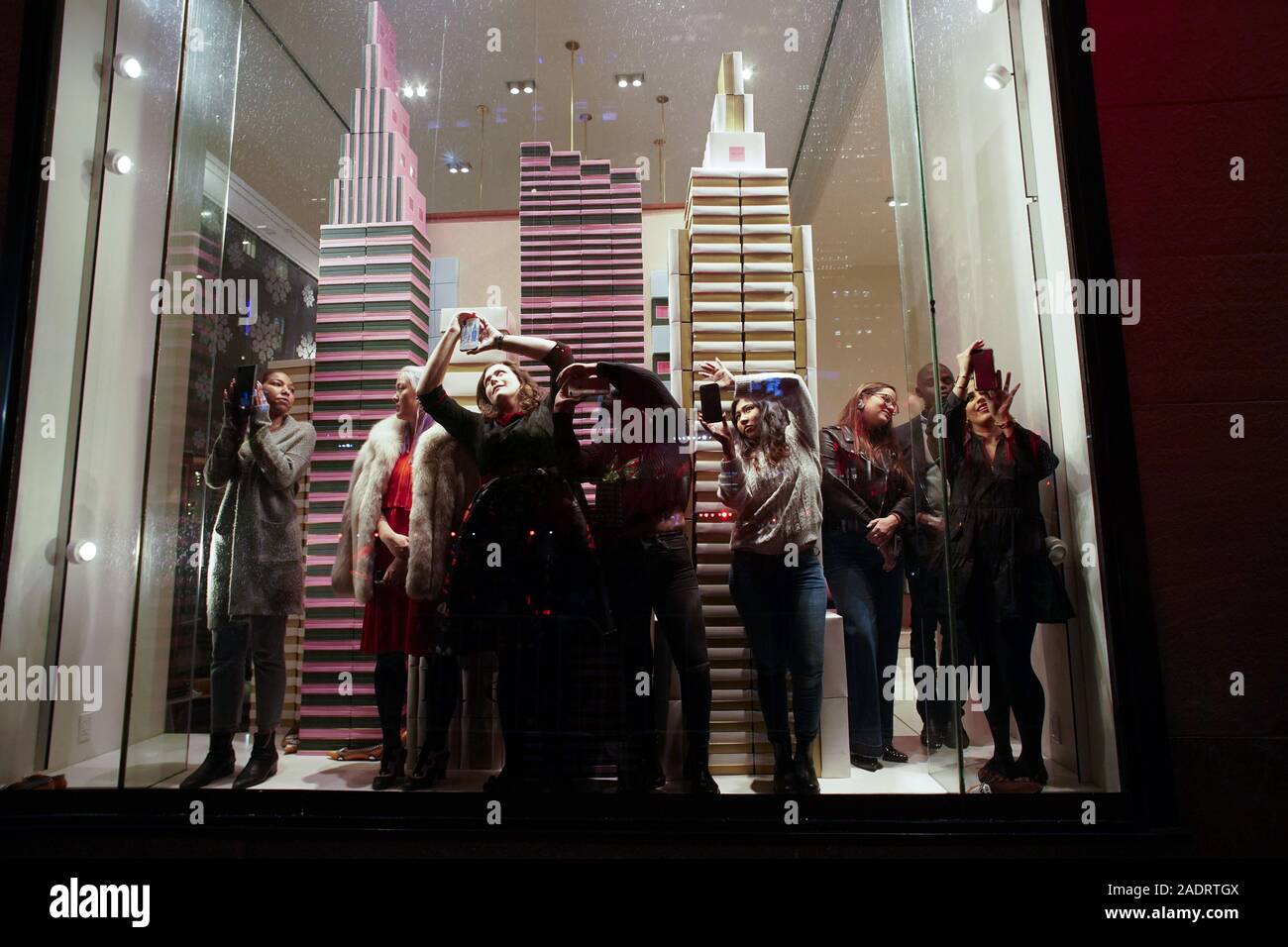 New York, États-Unis. 9Th Jul 2019. Un groupe de personnes de prendre des photos de l'intérieur d'une fenêtre d'affichage kate spade new york au magasin avant l'arbre de Noël les feux sont allumés pour la première fois à la 87e Cérémonie annuelle d'illumination de l'arbre de Noël du Rockefeller Center à New York le Mercredi, Décembre 4, 2019. Photo de John Angelillo/UPI UPI : Crédit/Alamy Live News Banque D'Images