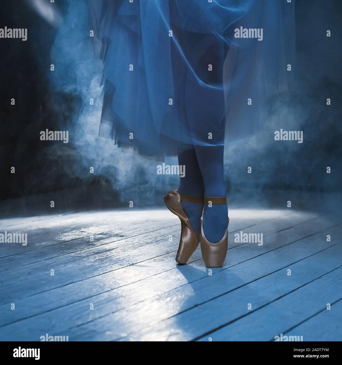 Les pieds de ballerine dans la fumée bleue. Position de ballet. Banque D'Images