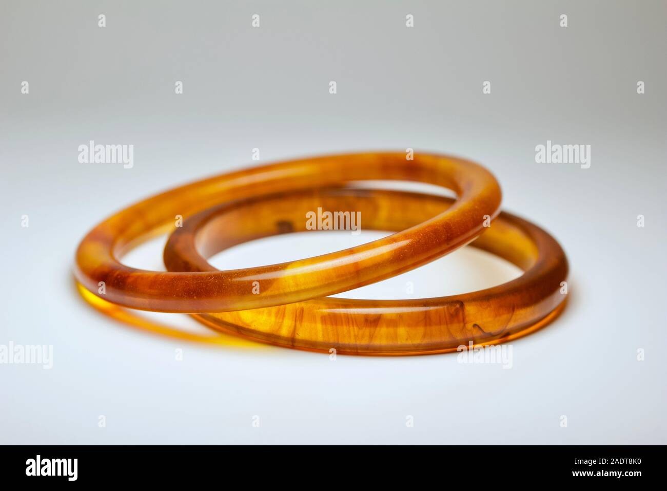 Vue rapprochée de l'écaille de tortue vintage deux bangle bracelets en bakélite de couleur sur fond blanc Banque D'Images