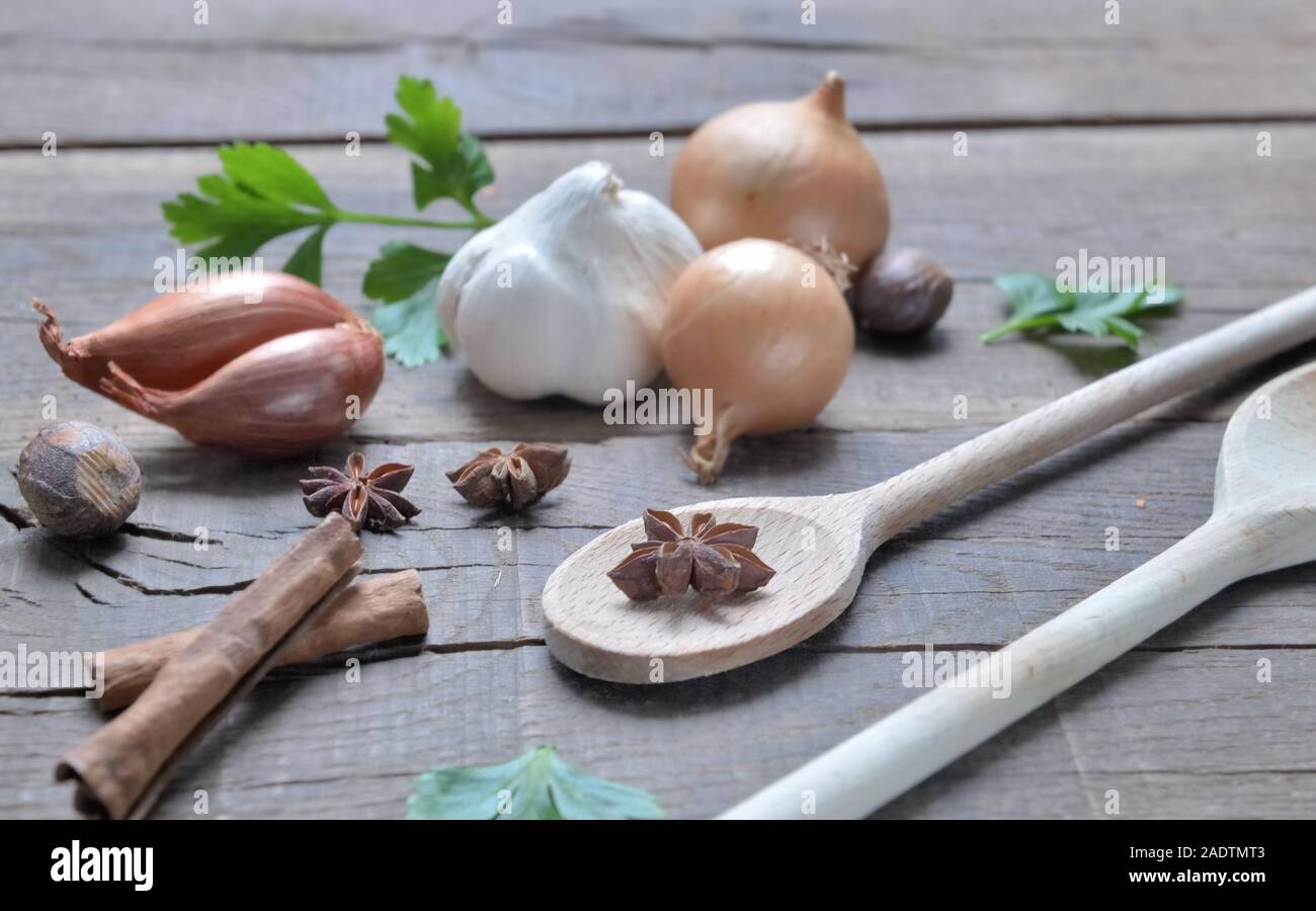Arrangement rustique avec condiment culinaire et cuillère en bois sur une planche Banque D'Images