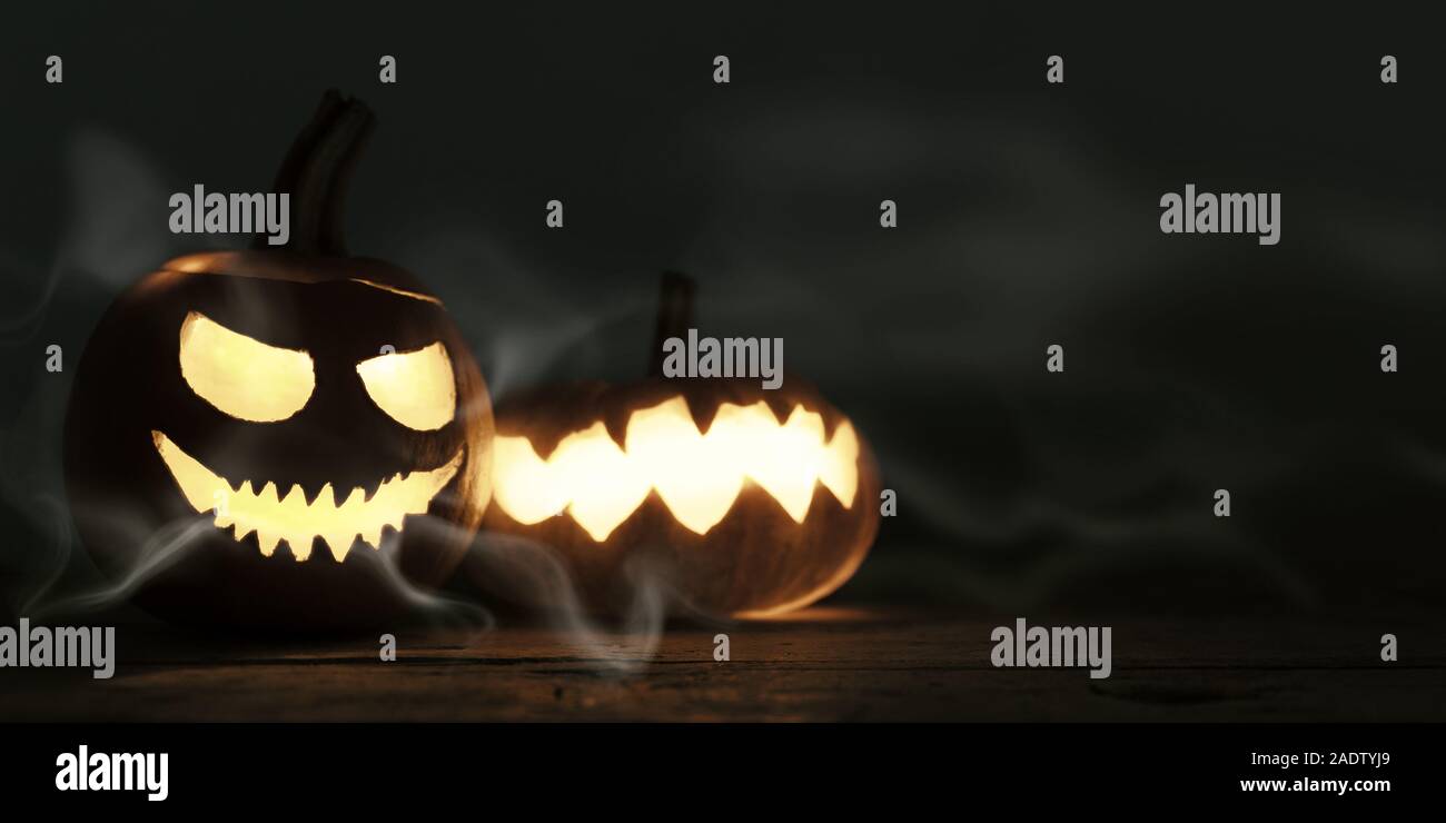 Décoration Halloween sur fond de bois sculpté, avec des grimaces effrayantes citrouilles et la lumière en face de ciel nocturne, copie de l'espace pour texte pour soirée à thème Banque D'Images