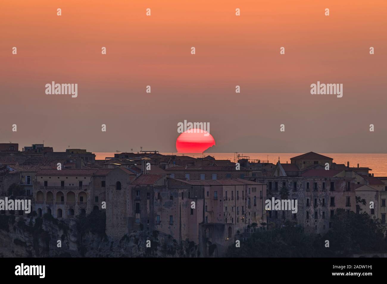 Coucher de soleil rouge avec de gros juste au dessus de l'horizon à l'horizontale de Tropea Banque D'Images