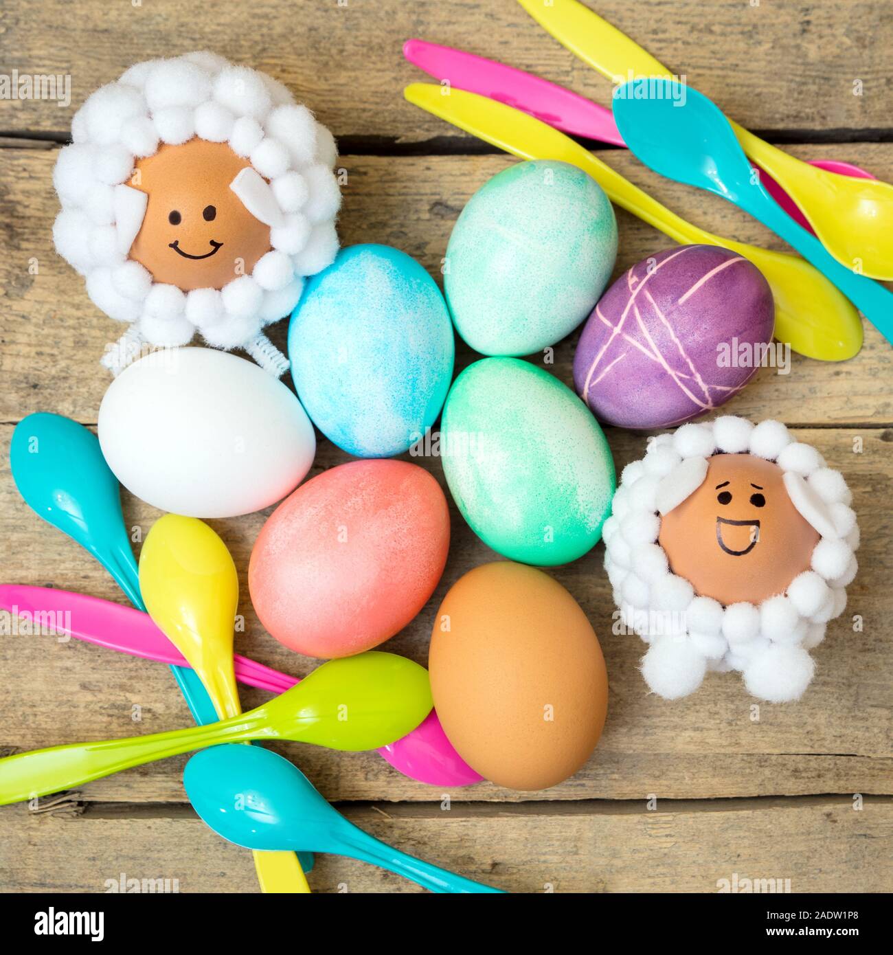 Flatlay Pâques, des cuillères, des œufs teints colorés en forme d'agneau et des chiffres sur la table en bois Banque D'Images