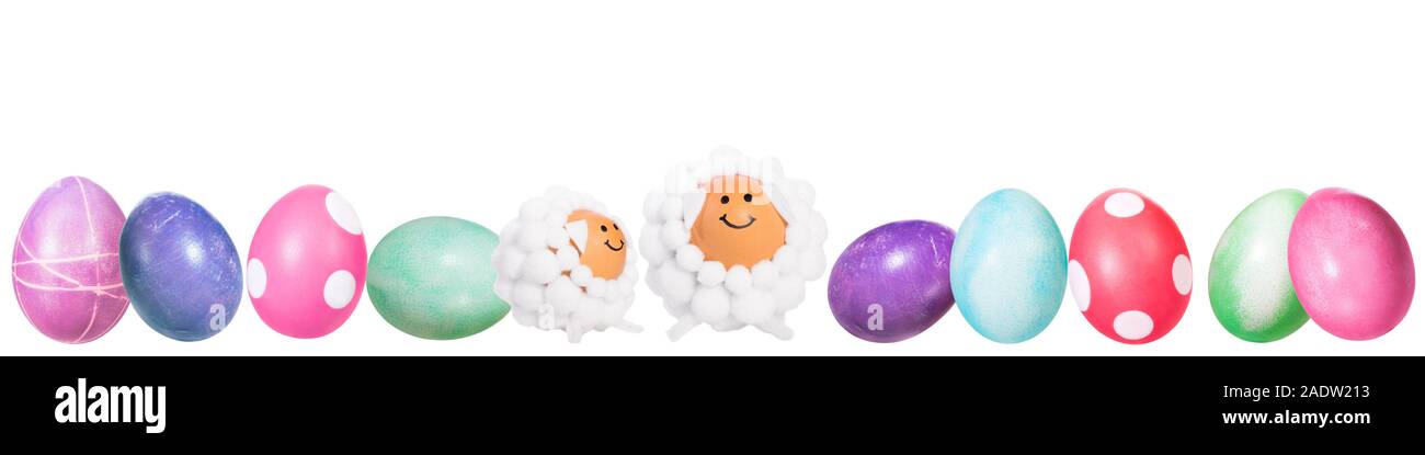 Bannière, les oeufs de pâques teints colorés et deux drôles d'oeufs en forme d'agneau dans une ligne, isolated on white Banque D'Images