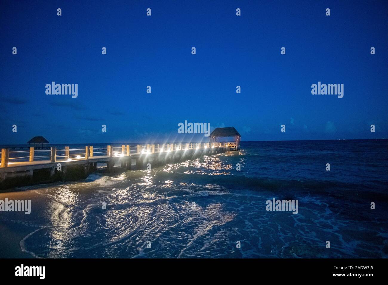 Passerelle en bois allumé en mer des Caraïbes par nuit Banque D'Images
