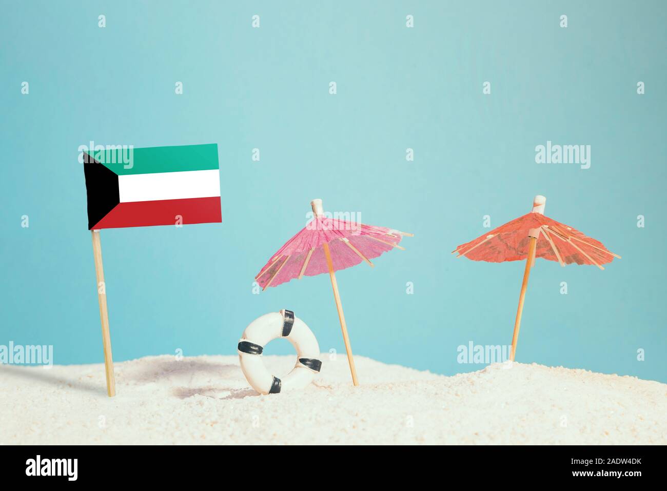Drapeau miniature du Koweït sur plage avec parasols colorés et conservateur de vie. Concept de voyage, thème d'été. Banque D'Images