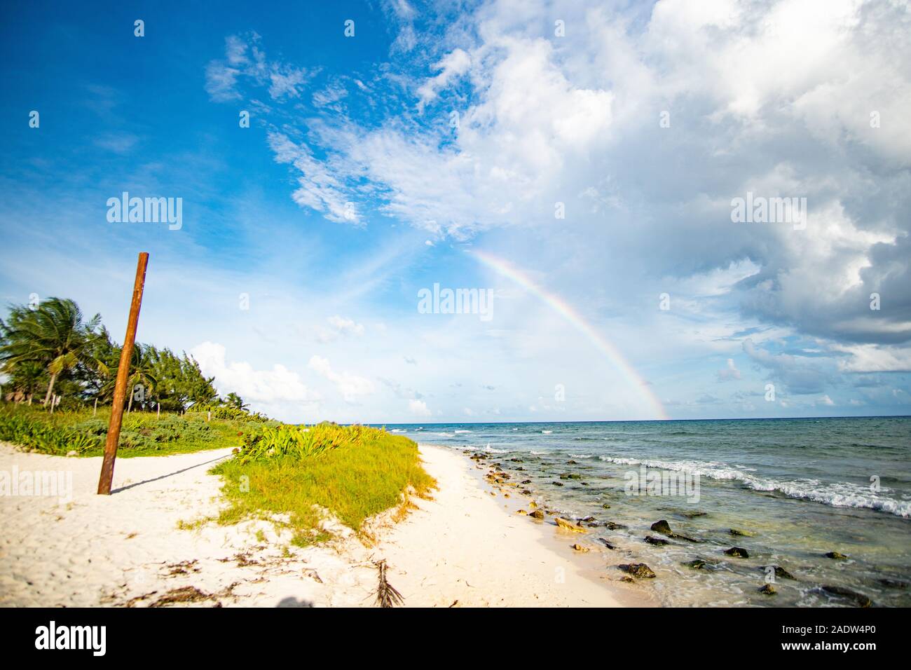 Arc-en-ciel magnifique demi et à la plage Banque D'Images