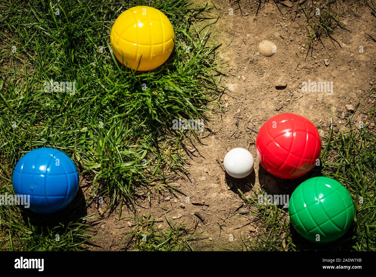 Un grand nombre de boules en plastique coloré ou balles de boccia se trouvent sur un pré vert à l'été Banque D'Images