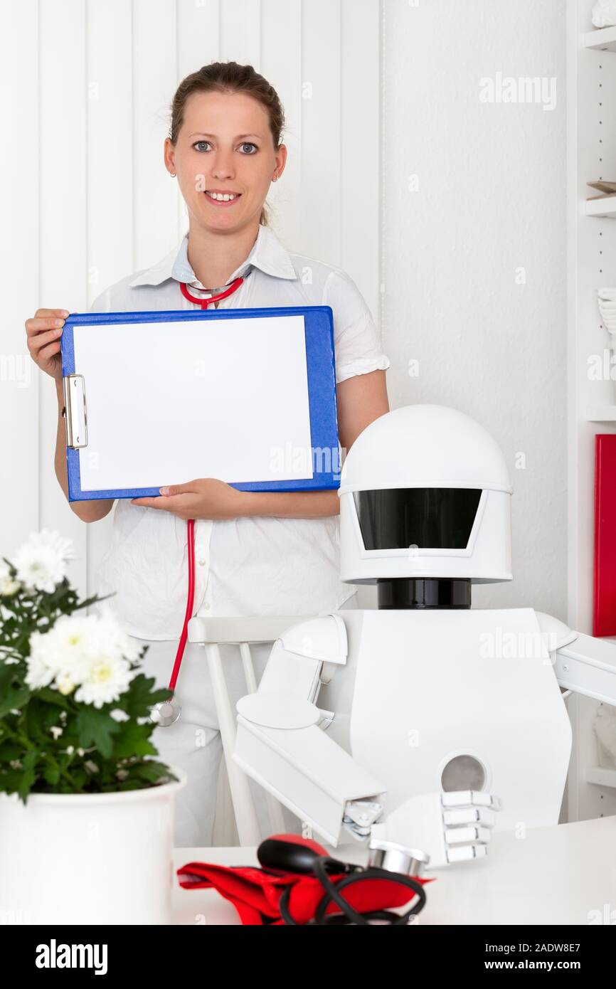Robot ia comme médecin professionnel dans son bureau, assis derrière le bureau, une infirmière ou un deuxième médecin femme avec presse-papiers dans ses mains Banque D'Images