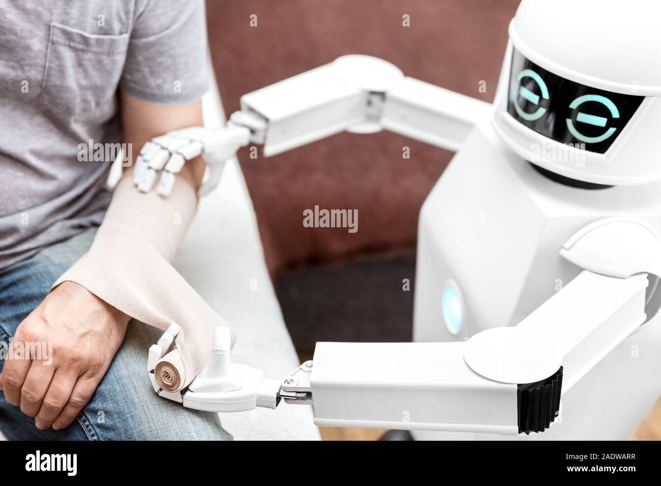Service de médecine d'assistance robot est de mettre un pansement sur un bras d'un patient de sexe masculin, à la maison dans la chambre à coucher Banque D'Images