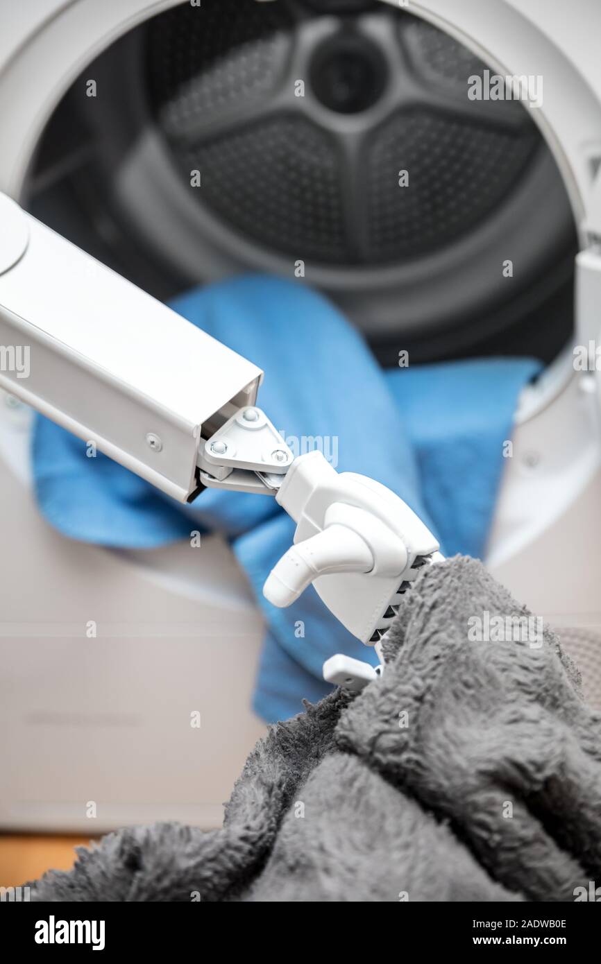 L'assistance à l'autonomie ou robot cyborg travaille dans le ménage. robot est de mettre quelques vêtements dans le sèche-linge Banque D'Images