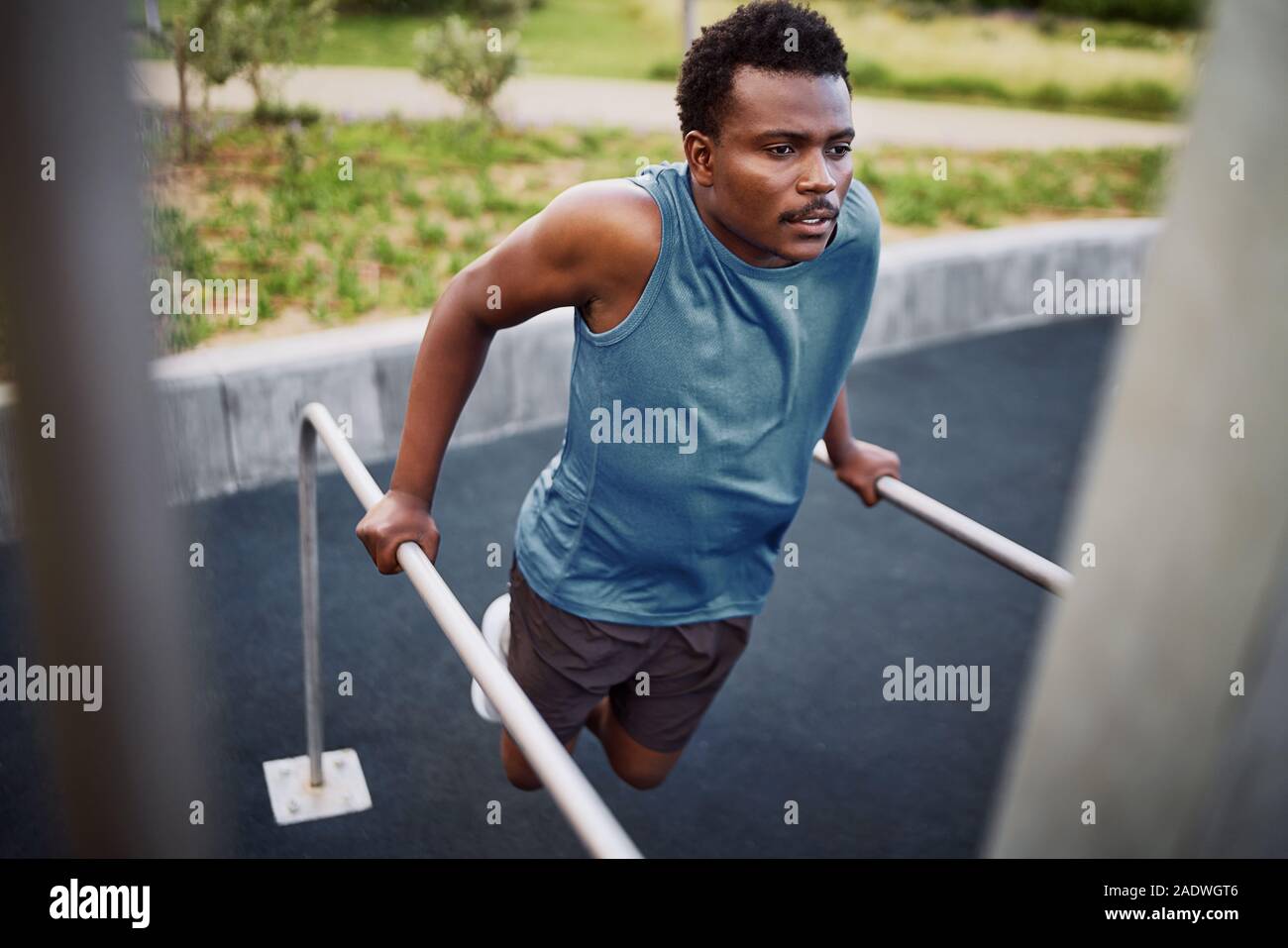 Young african american fit man doing triceps dips de barres parallèles à un sport en plein air park Banque D'Images