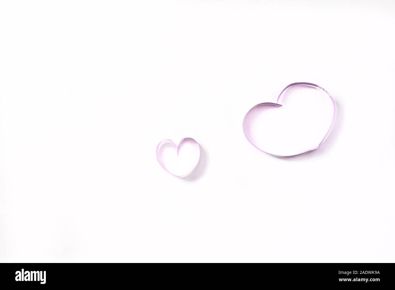 Deux coeurs à un ruban, une grande et une petite forme de coeur. Symbole de l'amour maternel, la grossesse. Banque D'Images