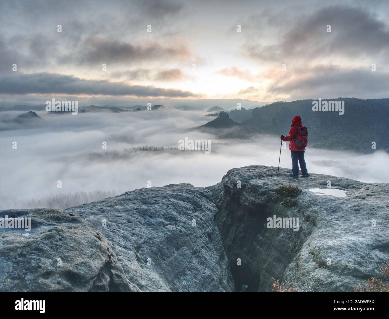 Femme seule randonneur dans les rochers tandis que l'extrême misty météo. Randonnée d'automne dans les montagnes rocheuses pour aventurier dur Banque D'Images