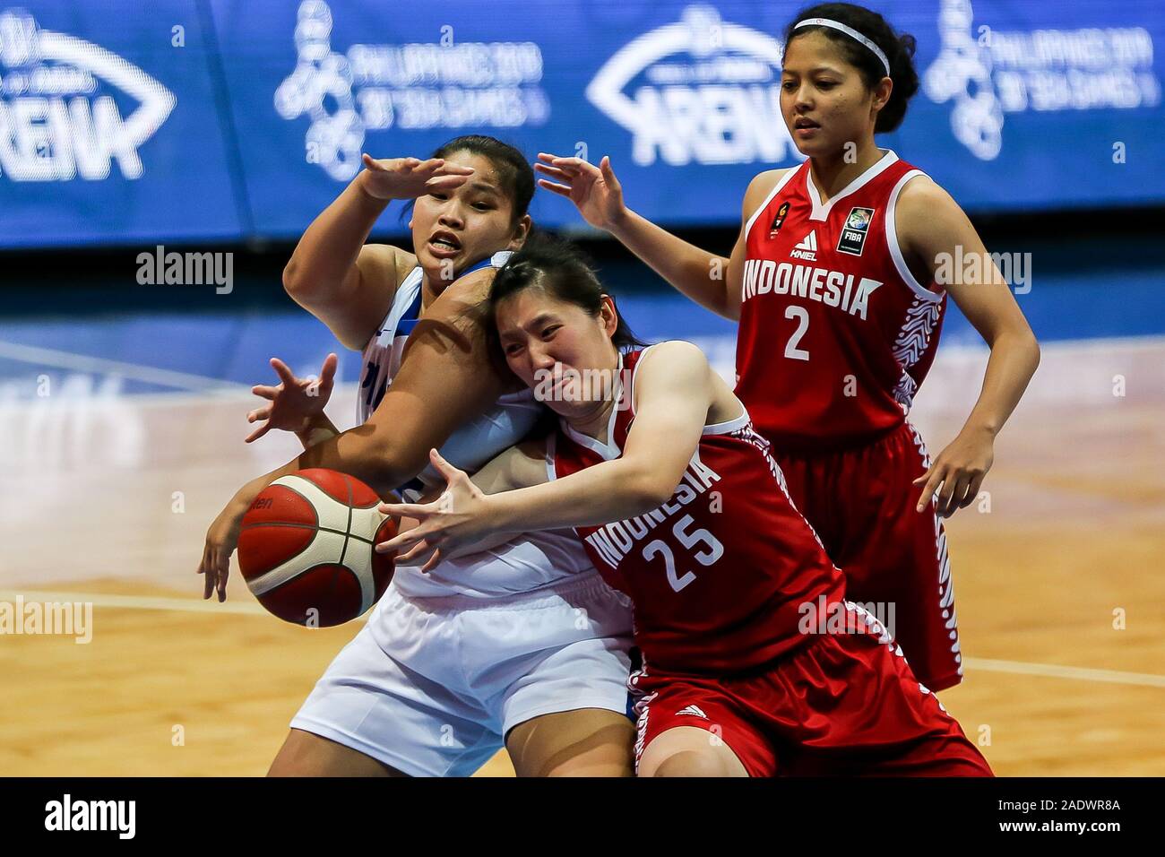 Pasay City, Philippines. 5 déc, 2019. Eunique Chan (L) des Philippines est  en concurrence avec Henny Sujitono (C) et Agustin Elya Gradita Retong de  l'Indonésie au cours de l'équipe féminine de basketball