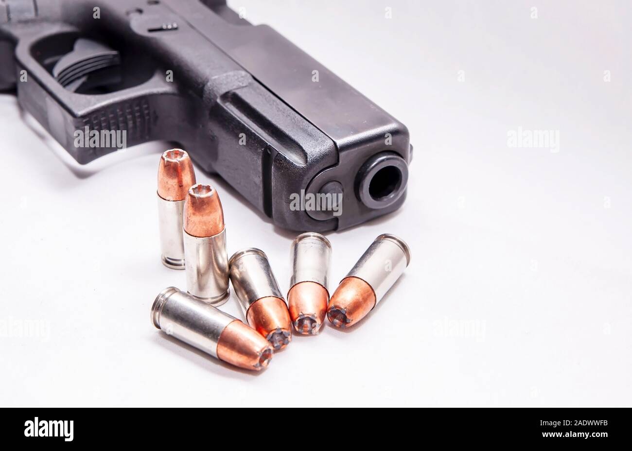 Six balles à pointe creuse de 9 mm à l'avant d'un pistolet 9 mm noir sur  fond blanc Photo Stock - Alamy