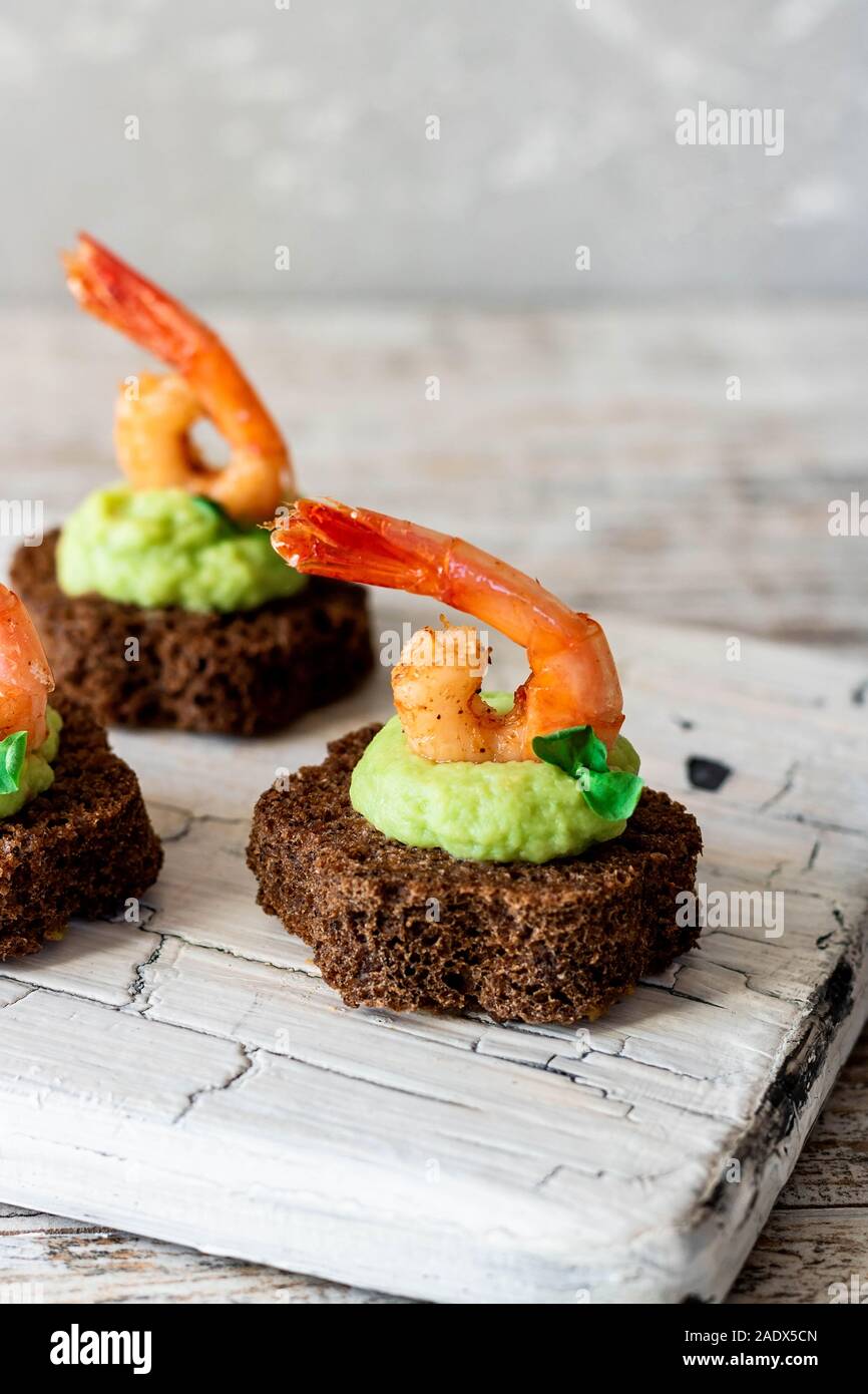 Des canapés à l'avocat et crevettes ail musulmane sur le pain brun. Snack-simple et facile pour les fêtes et banquets. L'alimentation confortable. Banque D'Images