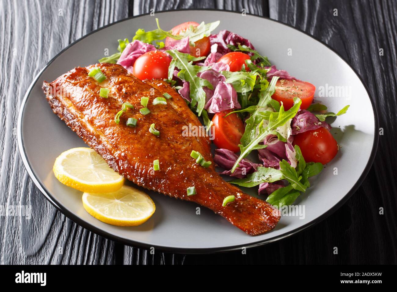 Une alimentation saine avec des poissons la perche rouge poêlé salade de légumes frais close-up dans une assiette sur la table horizontale. Banque D'Images