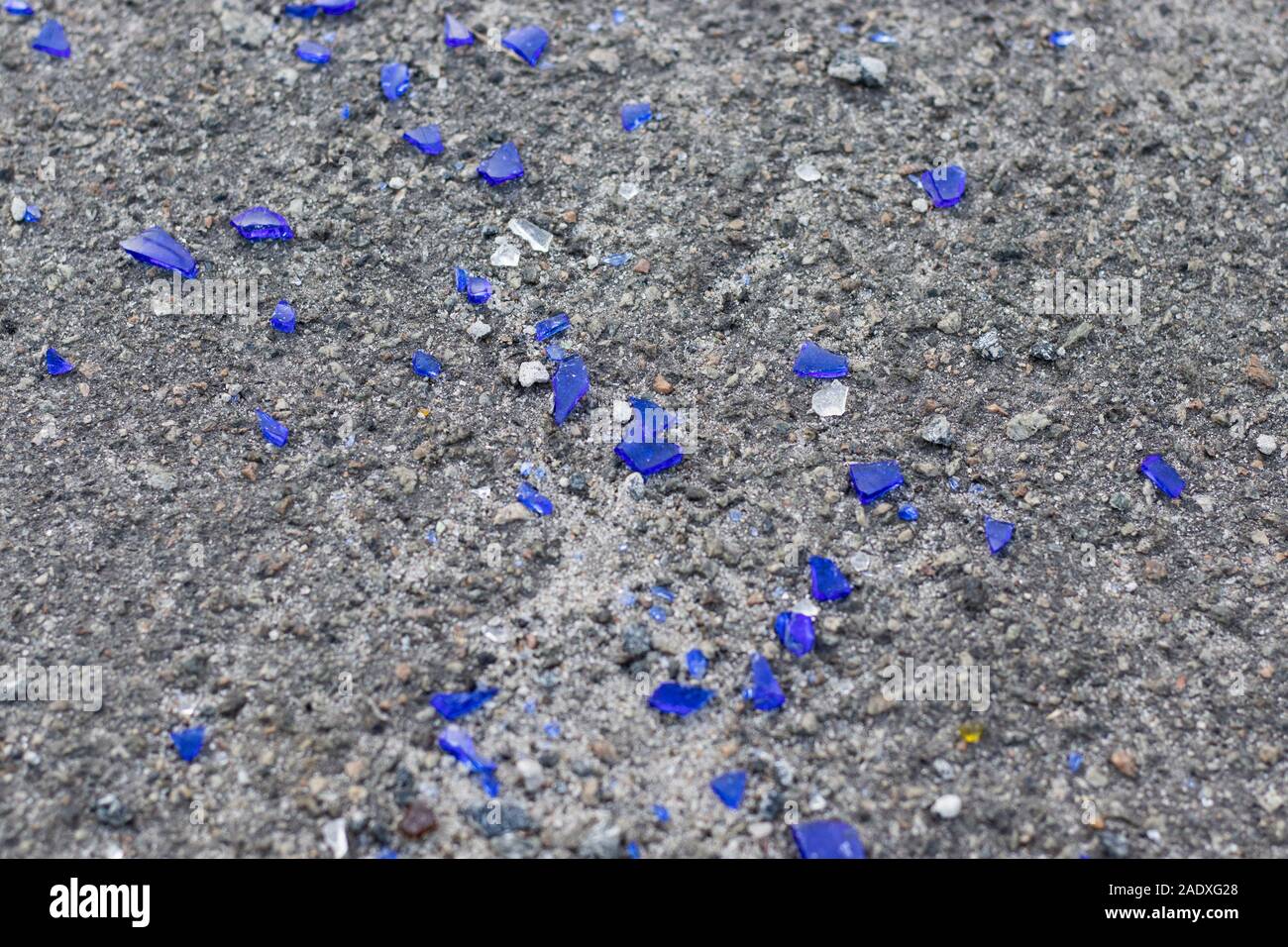 De petits morceaux de verre bleu cassé sur l'asphalte. Casse bouteille bleu texture Banque D'Images