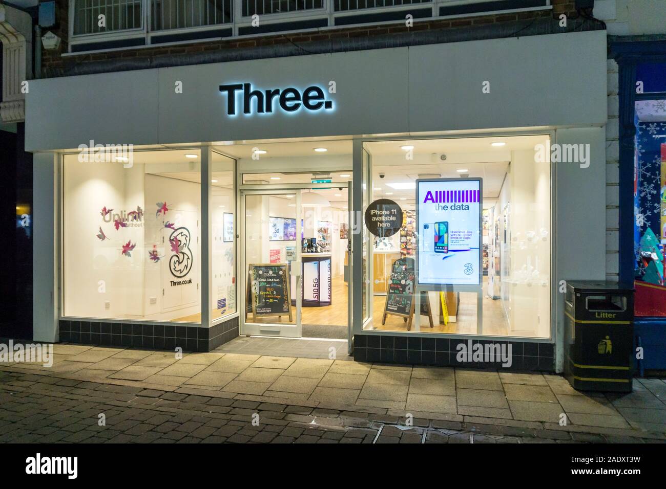 Un téléphone portable trois shop à King's Lynn High Street la nuit. Banque D'Images