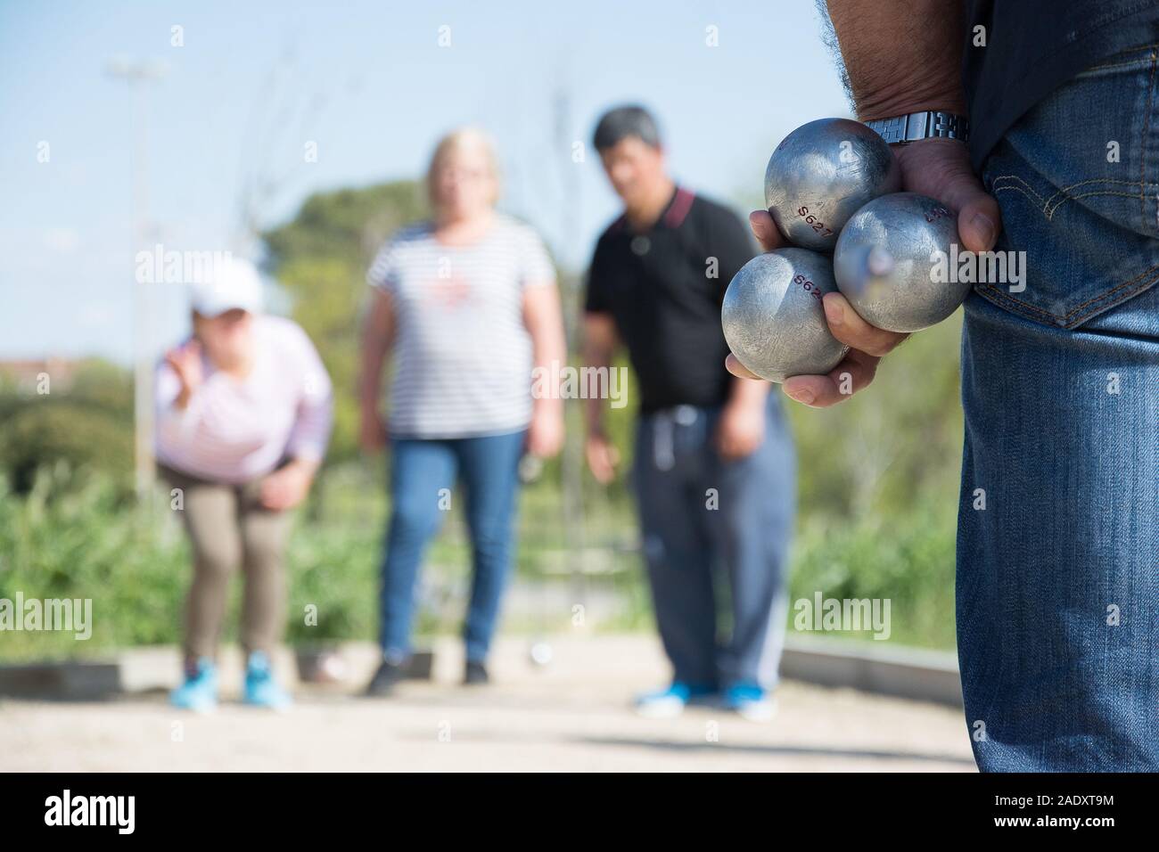 Les cadres prêts à jeter la boule de pétanque dans un parc de jeux à l'extérieur Banque D'Images