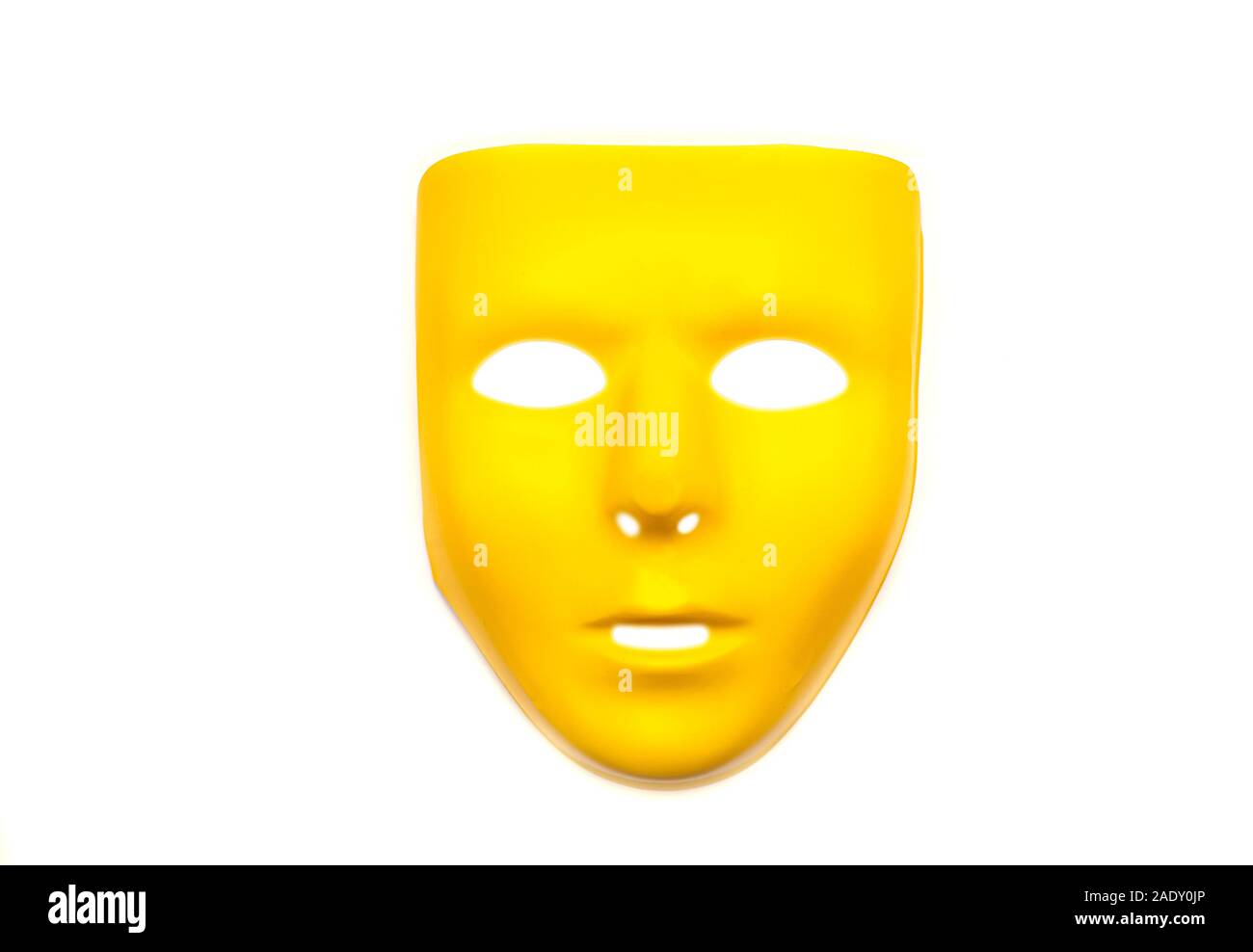 Masque en plastique jaune, masque pour le carnaval, le visage de l'Anonymat isolé sur fond blanc Banque D'Images