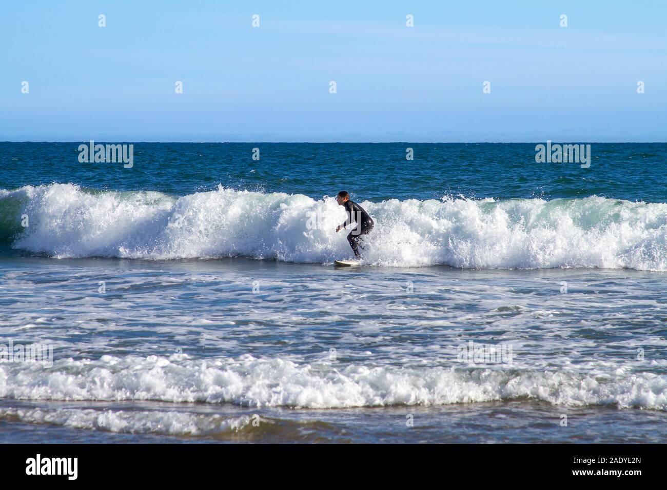 Newport Beach, CA / USA - Avril 6, 2019 : un jeune homme est ocean surf comme les vagues pause près du rivage à Newport Beach, en Californie. Banque D'Images