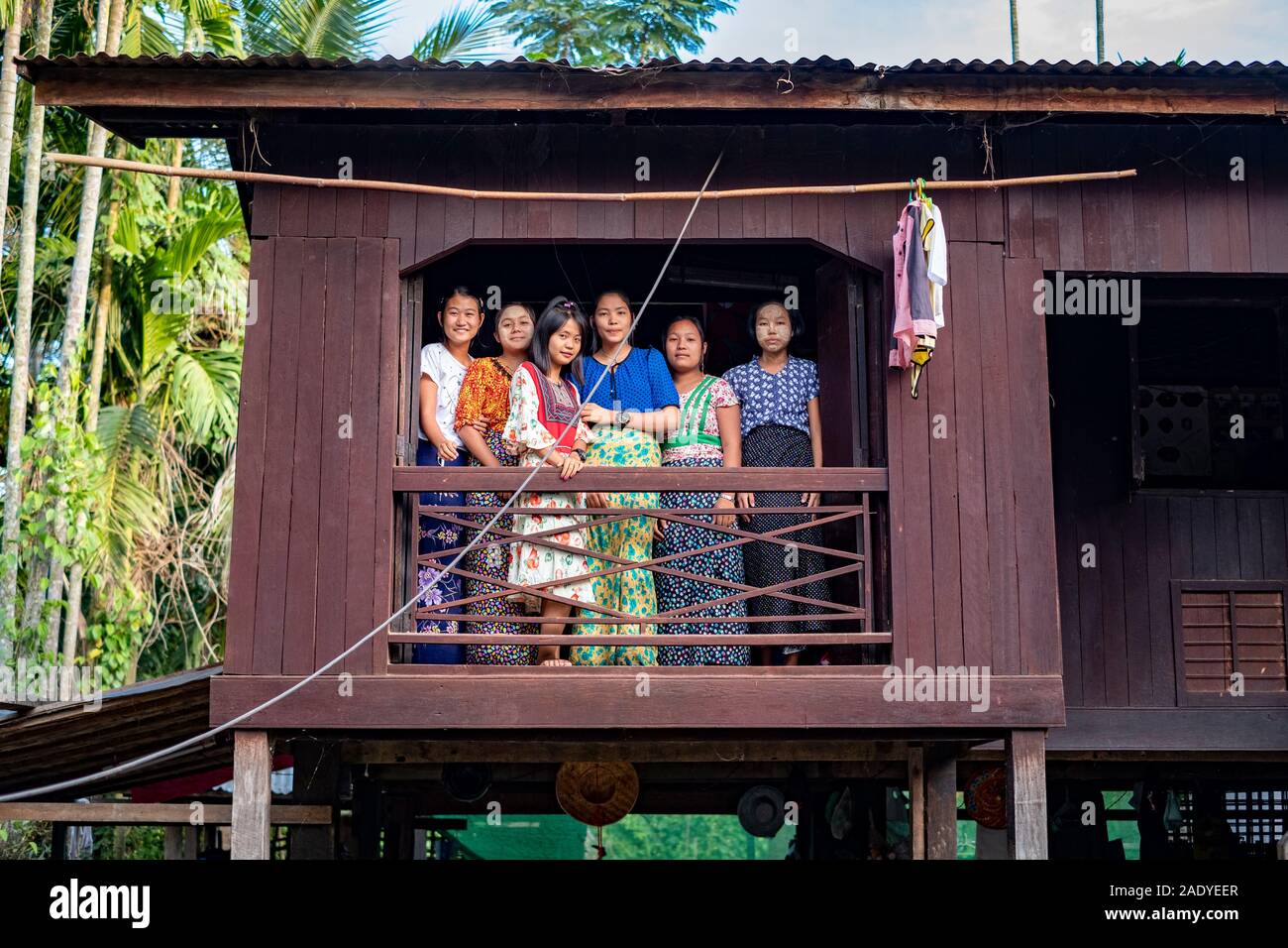 Six jeunes filles, à partir d'une fenêtre dans leur maison en bois dans un petit village le long de la rivière Chindwin, dans le nord-ouest de Myanmar (Birmanie) Banque D'Images