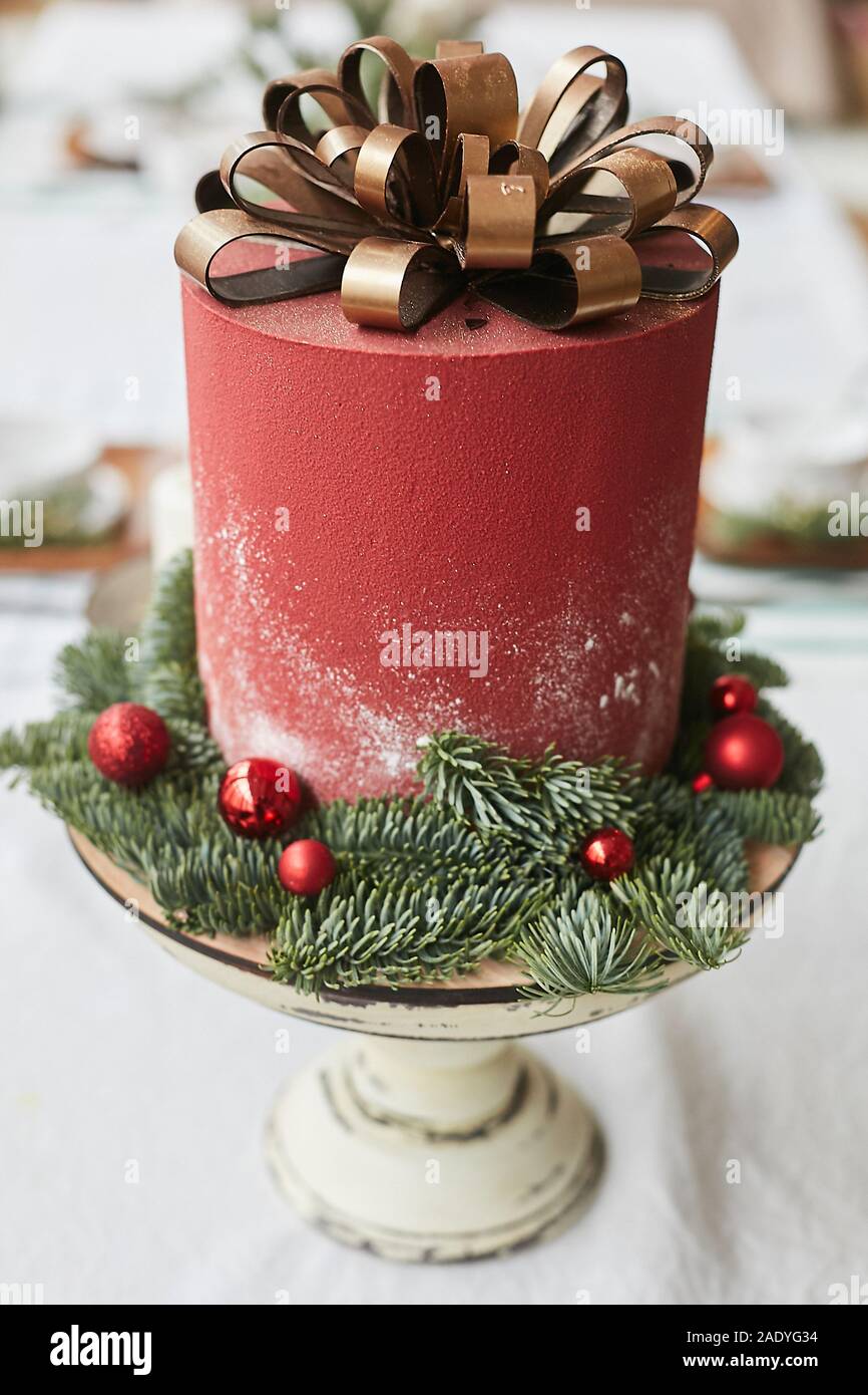 Gateau De Noel Rouge Avec Des Rubans D Or Au Chocolat Sous La Forme D Arc Decore Avec Des Boules Rouges Et De Branches Sur Le Support En Bois Patisserie Pour Le Nouvel An