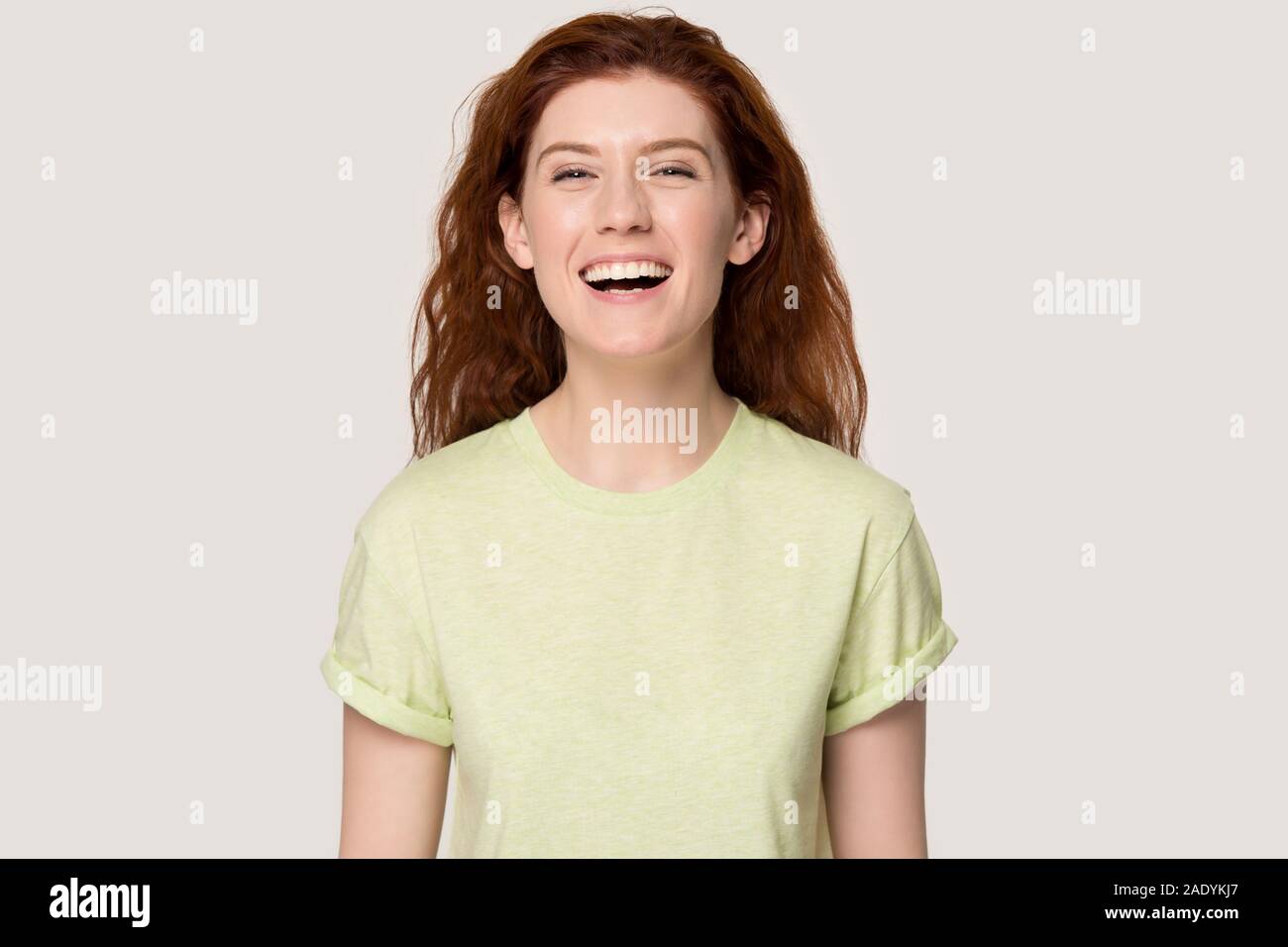 Head shot studio portrait smiling red-haired woman, riant de blague. Banque D'Images