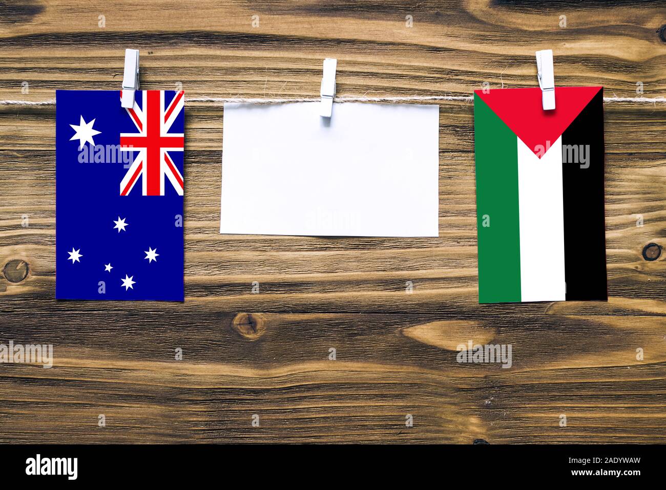 Drapeaux suspendus de l'Australie et la Palestine attaché à corde avec pinces à linge avec de l'espace de copie sur papier blanc sur fond de bois.e diplomatique Banque D'Images