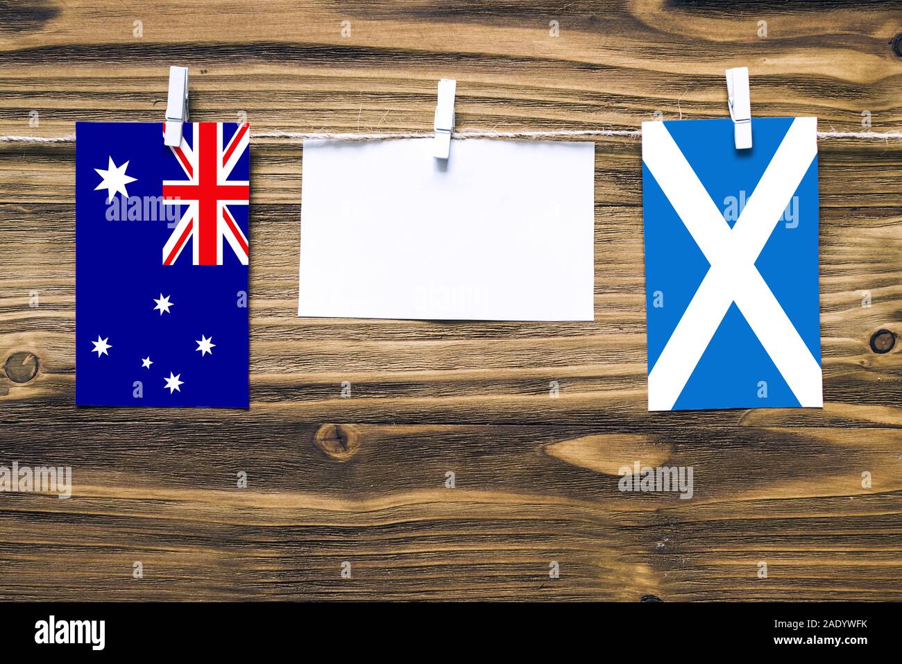 Drapeaux suspendus de l'Australie et l'Écosse attaché à la corde avec des pinces à linge avec de l'espace de copie sur papier blanc sur fond de bois diplomatique.relatio Banque D'Images