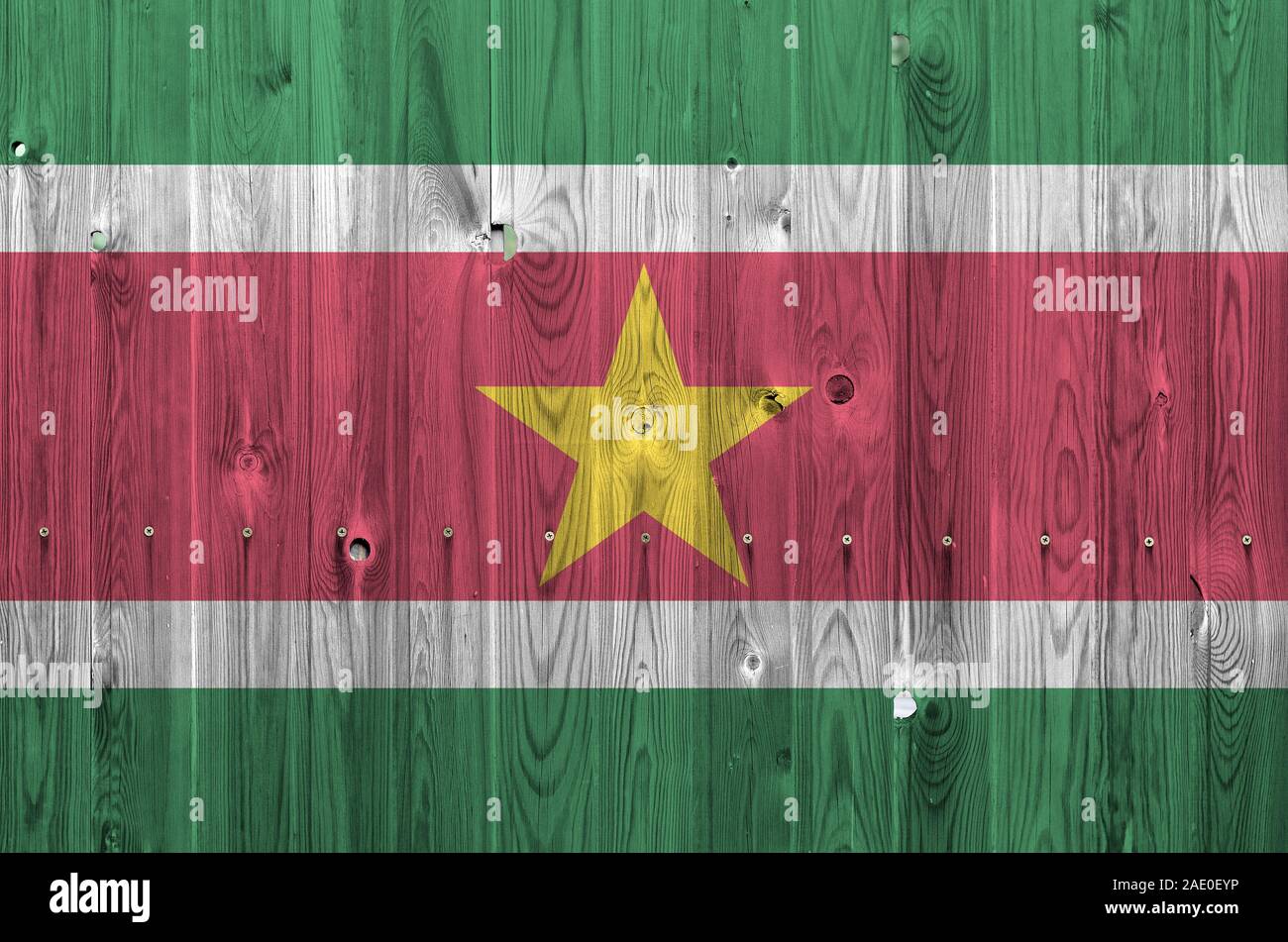 Drapeau Suriname représenté dans des couleurs de peinture sur mur en bois vieux de près. Bannière sur fond rugueux texturé Banque D'Images