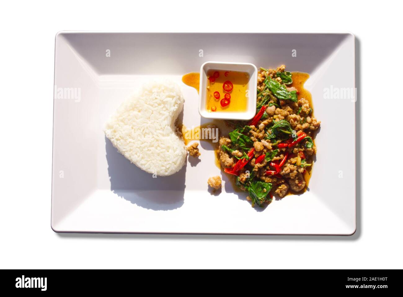 Sauté de porc riz avec des feuilles de basilic sur un fond blanc. Banque D'Images