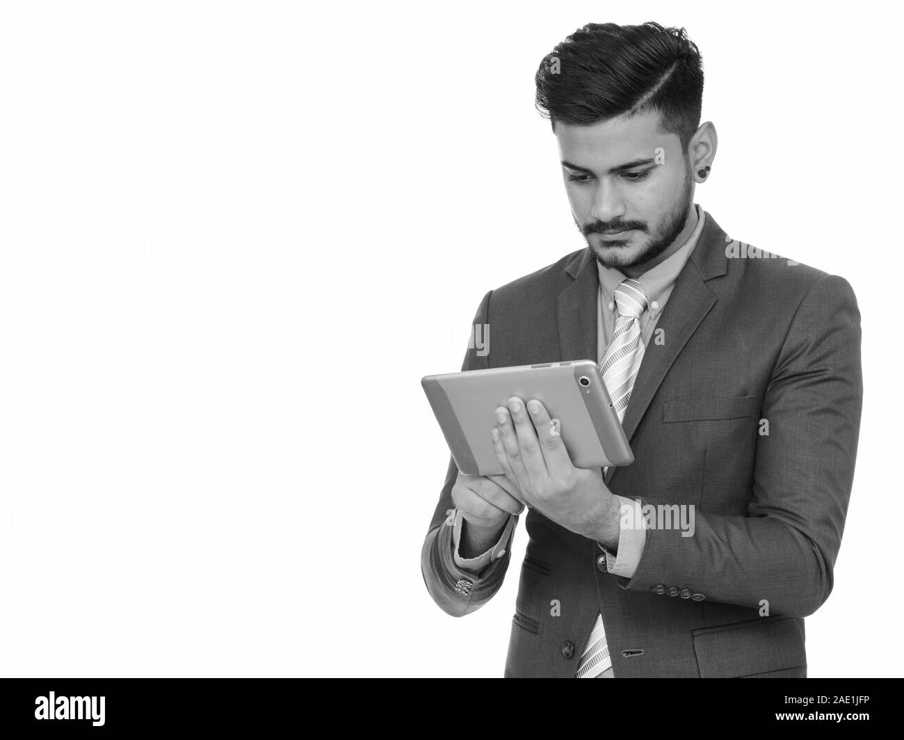 Young handsome Indian businessman using digital tablet Banque D'Images