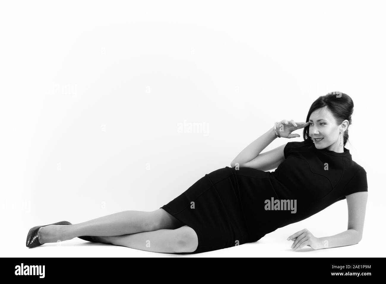 Full body shot of woman smiling et couché en pensant Banque D'Images