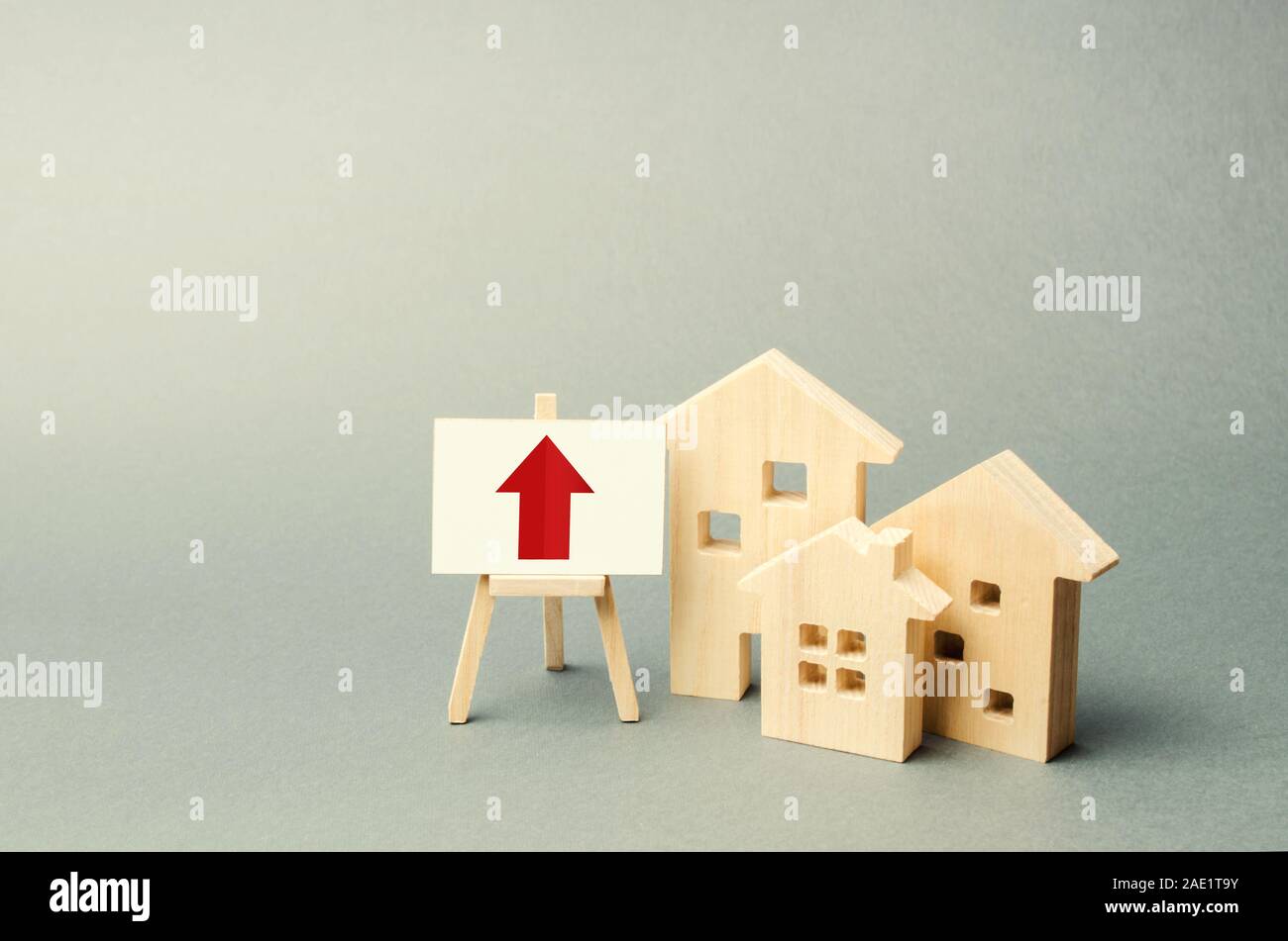 Trois maisons en bois et une flèche rouge sur le signe. Augmenter la valeur de l'immobilier. Des taux élevés de construction, forte liquidité. L'offre et de la demande. La hausse Banque D'Images