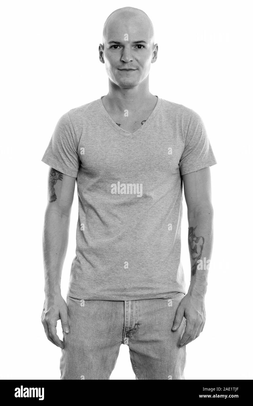 Studio shot of young handsome bald man standing Banque D'Images Studio shot of young handsome bald man standing Banque D'Images
