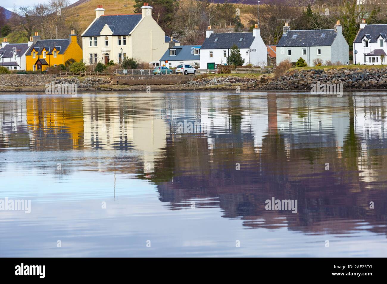 À l'échelle du village de Dornie, reflétée dans le Loch Long, dans l'ouest de Ross, l'ouest des Highlands, Ecosse, Royaume-Uni en mars Banque D'Images