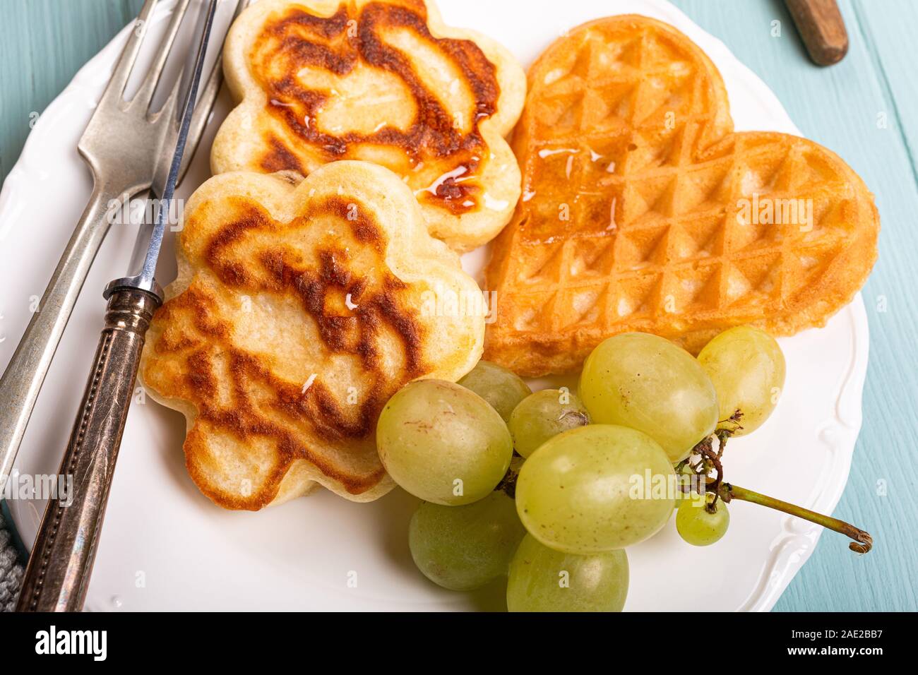 Petit-déjeuner sain composé de gaufres, crêpes fleurs coeurs Banque D'Images